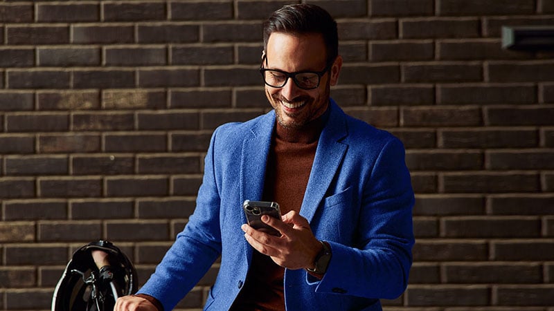 Hombre sonriendo mirando su smartphone