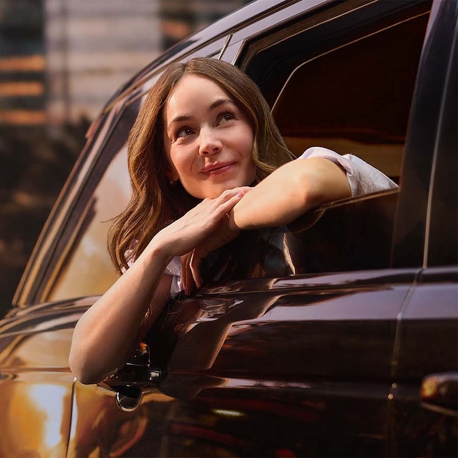 Camila Sodi asomada por la ventanilla de un auto en un atardecer