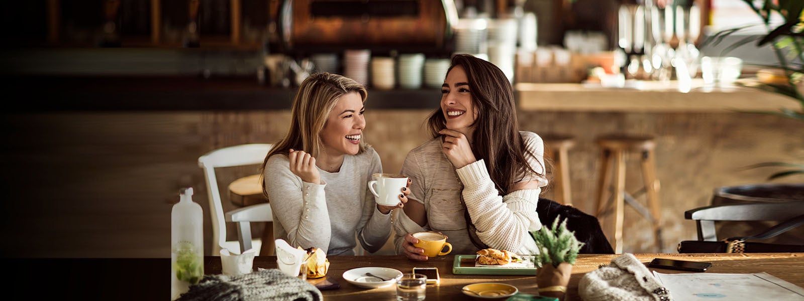 Mujeres sonrientes compartiendo un desayuno 