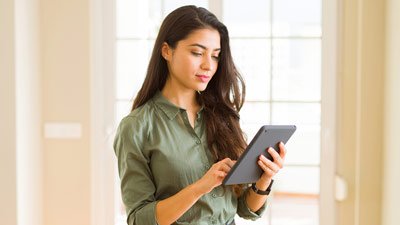 Mujer mirando su celular mientras camina por la ciudad