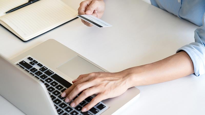 mujer pagando con tarjeta en laptop