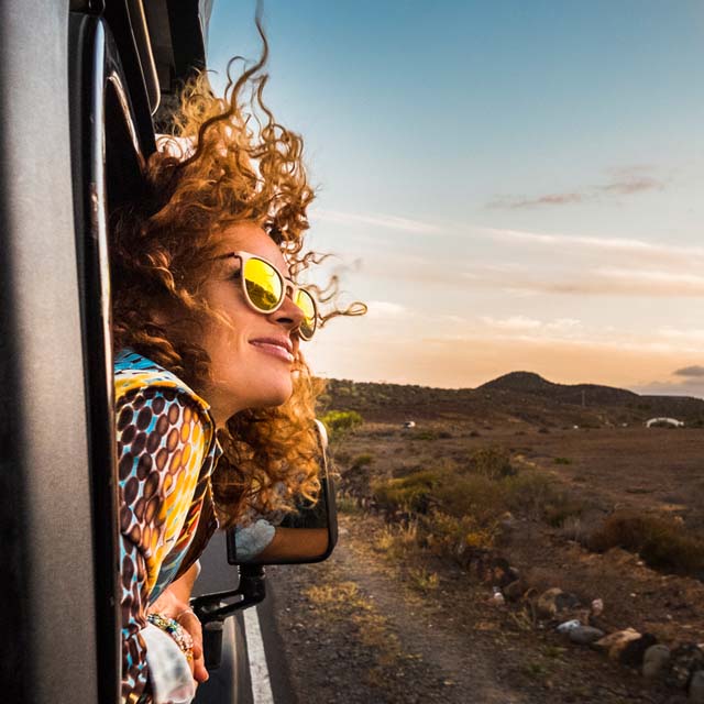 Mujer disfrutando del paisaje mientras viaja