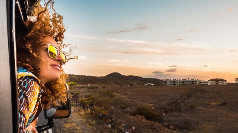 Mujer disfrutando del paisaje mientras viaja