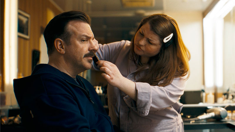 Hombre afeitandose el bigote junto a una mujer